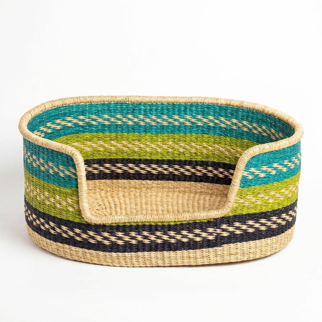 A woven oval pet bed made of natural seagrass with horizontal stripes of teal, lime green, black, and beige, set against a plain white background.